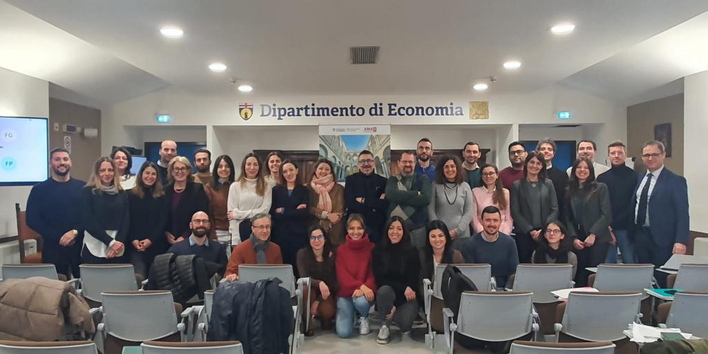 foto di gruppo di circa 25 giovani uomini e donne in posa in aula universitaria